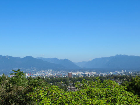 Panorama from Queen Elizabeth Park towards Vancouver with mountains on the background.