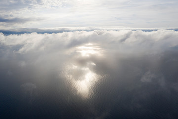 Naklejka na ściany i meble Aerial view clouds over the sea. View from drone. Aerial top view cloudscape. Texture of clouds. View from above. Sunrise or sunset over clouds. Aerial ocean background