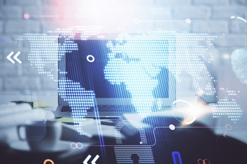 Double exposure of desktop with computer and world map hologram. International data network concept.
