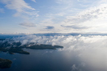 Aerial view clouds over the sea. View seashore and coastline from drone. Aerial top view cloudscape. Texture of clouds. View from above. Sunrise or sunset over clouds. Aerial ocean background