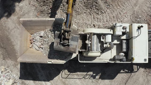 Smooth aerial view of demolition waste recycle machine on sunny day