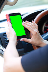 woman driver with a smartphone in her hands while driving