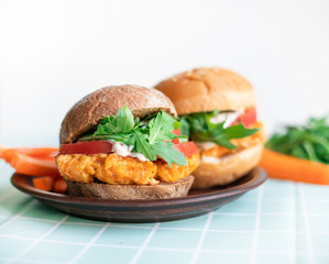 Vegan burger with carrot cutlet. Home cooking, simple recipe. Urger with carrot cutlet, tomato, arugula and homemade lean mainesis.