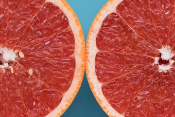 Fresh ruby red grapefruit isolated on light blue background.