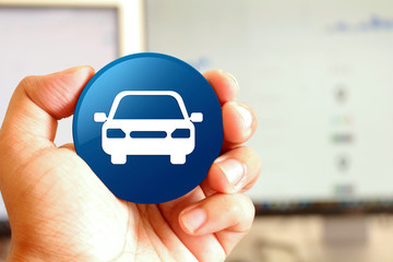 Car icon blue round button holding by hand infront of workspace background