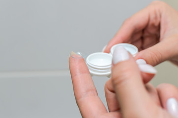 Removes contact lenses for vision correction and places them in a contact lens container
