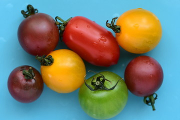 Fresh cherry tomatoes on light blue background.