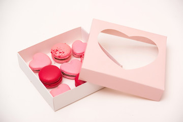Sweet macarons in gift box. Traditional french colorful macarons. Valentine's day gift. Pink macarons in the heart shape.