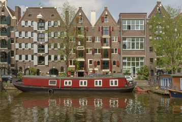 canal with typical houses and houseboats in Amsterdam