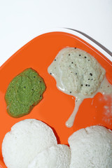 South Indian breakfast recipe Idly or Idli / rice cake served with coconut chutney and coriander mint chutney, selective focus
