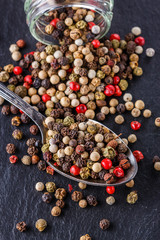 mix of peppercorns on a dark stone background