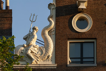 Neck gables with statues of neptune on a dutch house in Amsterdam