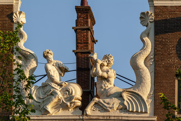 Neck gables with statues of triton and neptune on a dutch house in Amsterdam