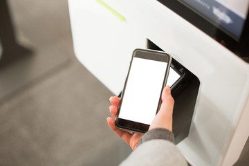 Woman paying at cafe with smartphone wirelessly on easy POS terminal