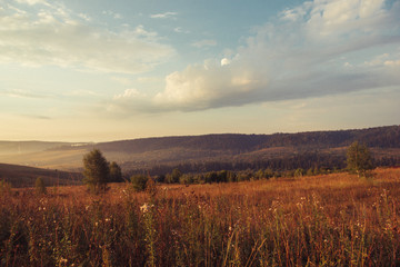 Fototapeta premium Russia. Travel across Russia. Hills, mountains and fields. Panorama at sunset.