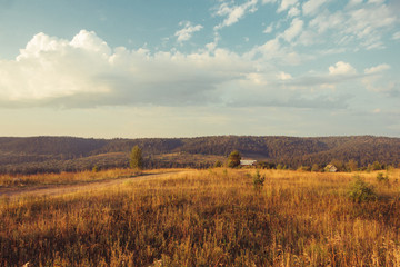 Fototapeta na wymiar Russia. Travel across Russia. Hills, mountains and fields. Panorama at sunset.