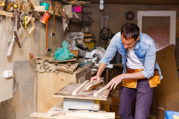 handsome joiner work in carpentry. He is successful entrepreneur at his workplace.
