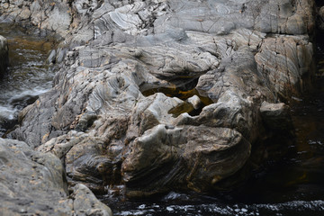 Eroded rocks besides a waterfall at Loch Arkraig the Scottish Highlands