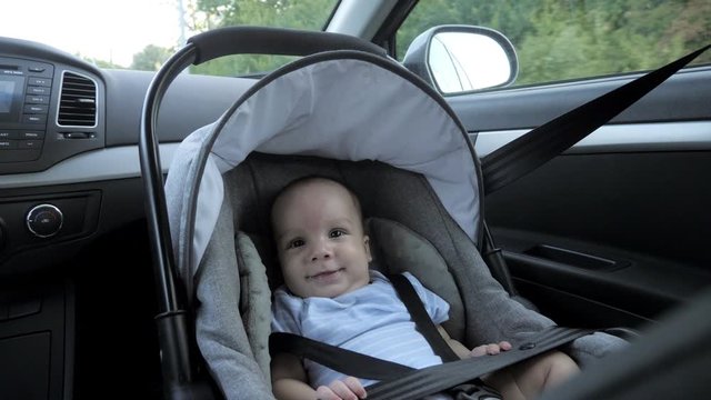 Little boy in a child safety seat sitting while car is driving