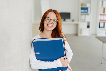 Smiling friendly young businesswoman with binder