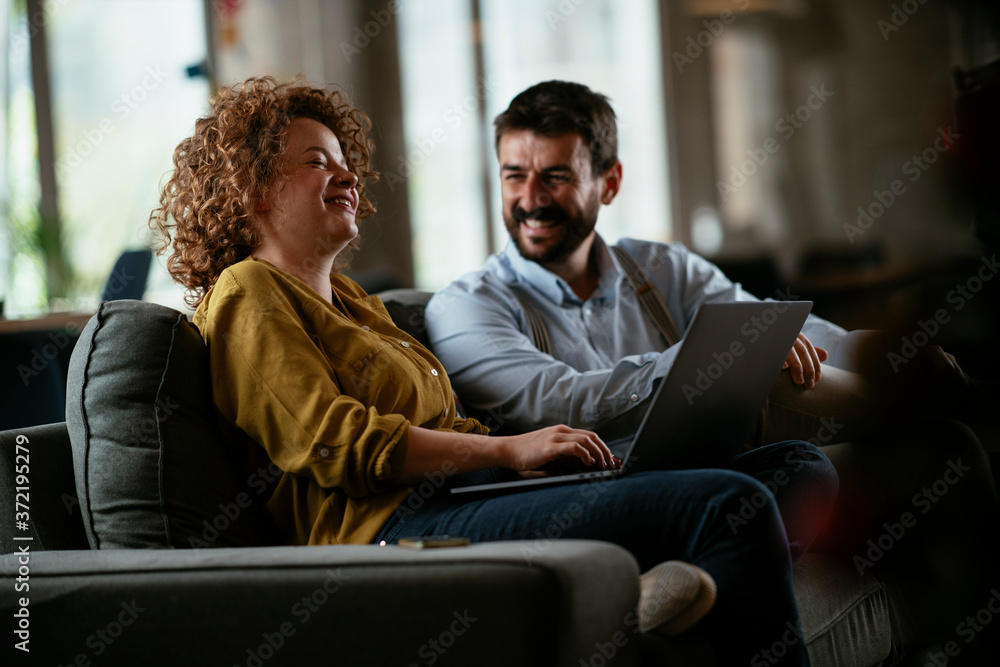 Wall mural Businesswoman and businessman discussing work in office. Two friends in working together.