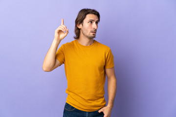 Fototapeta premium Young handsome man isolated on purple background intending to realizes the solution while lifting a finger up