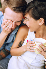 Laughing man and smiling woman with cup of cappuccino