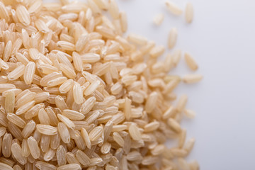 raw brown rice on white acrylic background