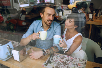 Man talking to woman with cup of cappuccino