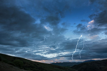 Naklejka na ściany i meble Dramatic landscape with thunder lightning. Otago. Lindis Pass near Cromwell. New Zealand. Sunset.
