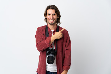 Young photographer man isolated on white background pointing to the side to present a product