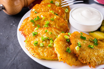 Delicious crispy potato pancakes on dark stone background