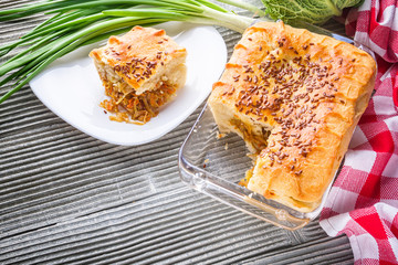 freshly baked cabbage pie on rustic wooden background