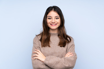 Young brunette woman wearing a sweater over isolated blue background keeping the arms crossed in...