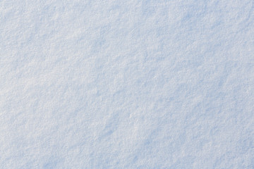Natural snow texture. Smooth surface of clean fresh snow. Snowy ground. Winter background with snow patterns. Perfect for Christmas and New Year design. Closeup top view.