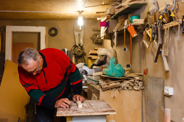 Carpenter works in a workshop for the production of vintage furniture