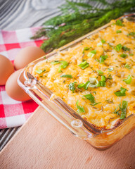Delicious potato casserole with egg and cheese on a gray wooden background