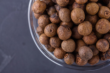 fresh spicy peppers allspice on a dark stone background