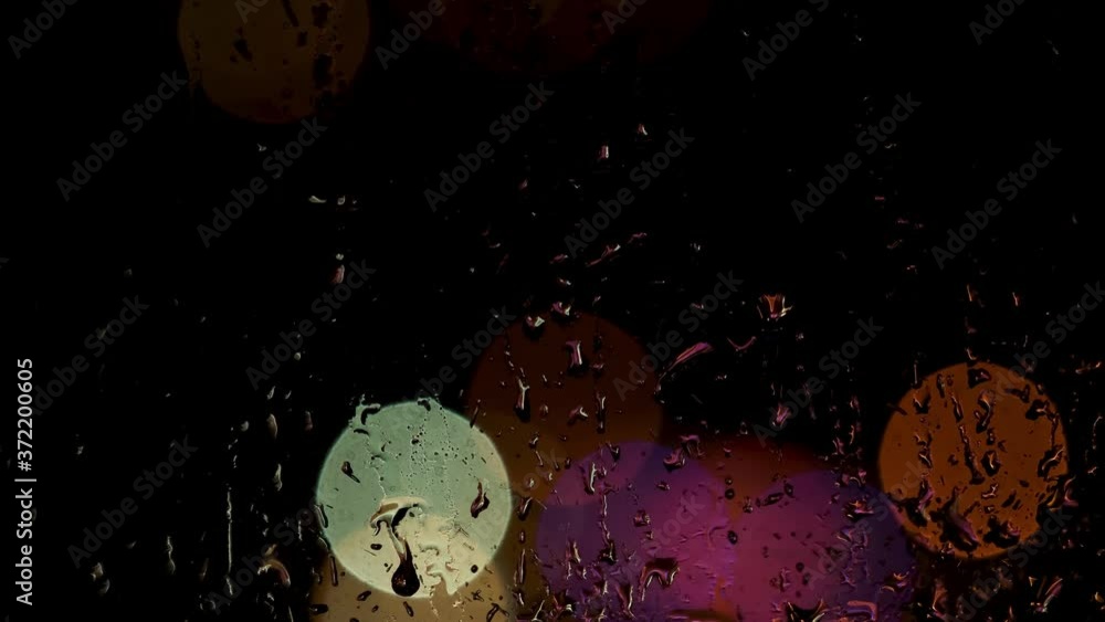 Aufkleber water drops on window trickling down on bokeh colorful lights background. concept. close up of wet w