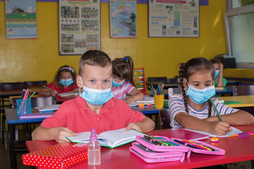 Elementary school children learn with masks on their faces