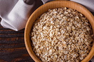 raw oatmeal on a wooden rustic background