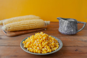 crisp canned corn, gravy boat and cobs on yellow wall