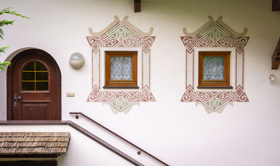 characteristic decorated house in Dorf Tirol village, near Meran, south Tirol, Bolzano province, northern  Italy. Detail of the small windows - obrazy, fototapety, plakaty