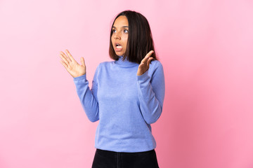 Young latin woman isolated on pink background with surprise facial expression