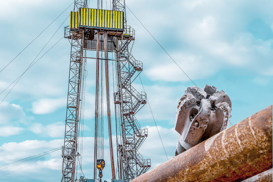 Oil and Gas Drilling Rig onshore dessert with dramatic cloudscape. Oil drilling rig operation on the oil platform in oil and gas industry.