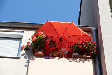 Sonnenschirm bei Hitzewelle im Sommer auf Balkon,