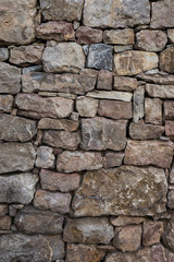 Dry stone wall background with textured rocks and stones.