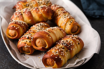 Pretzel dogs with sausages on black background. Oktoberfest.