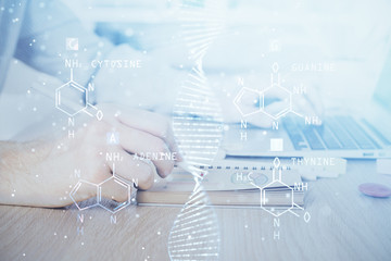 DNA hologram with businessman working on computer on background. Concept of bioengineering. Double...