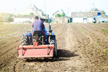 The farmer drives a tractor with a milling unit equipment. Loosening surface, land cultivation Use...
